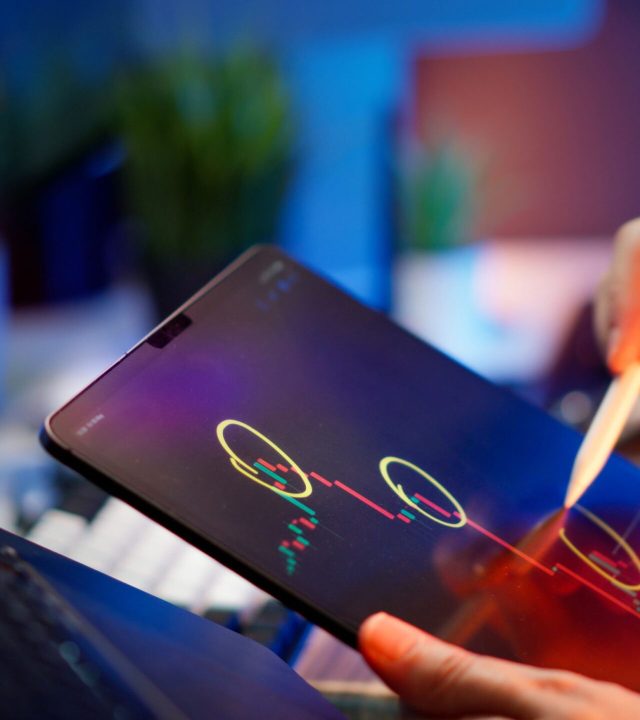 Person analyzing cryptocurrency trends on a tablet with digital pen.